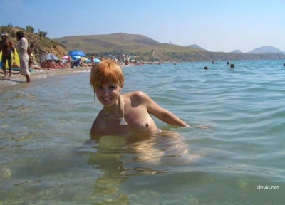 Рыжая нудистка отдыхает на пляже