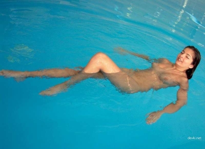 Девушка позирует голая в бассейне