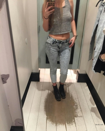 Pretty woman takes pictures of herself in the fitting room