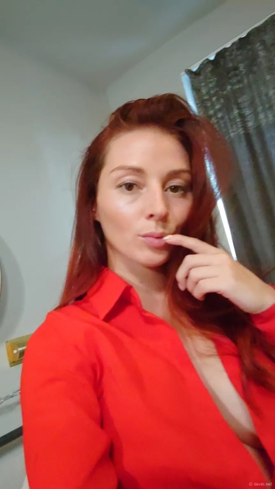 Naughty redhead shows off her big tits on camera