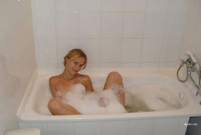 Худенькая девушка моется в ванной