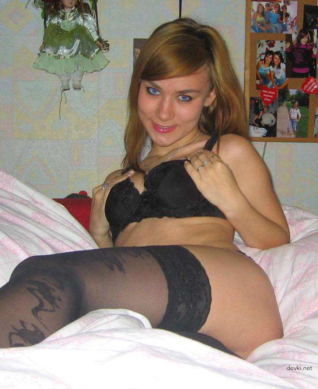 Сексуальна девушка в чулках позирует на кровати