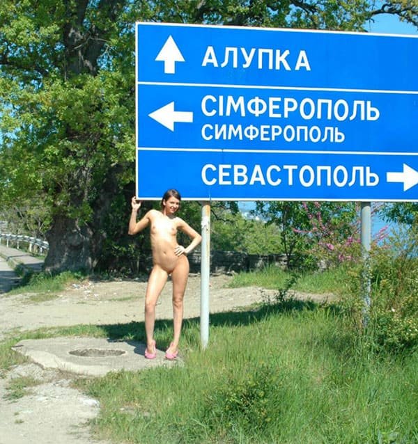 Naked girl at a road sign